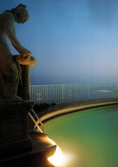 piscina con statua di notte - obrazy, fototapety, plakaty