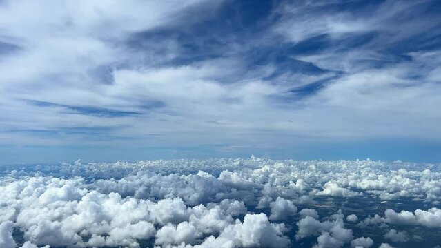The view from an airplane flying above the clouds during the day