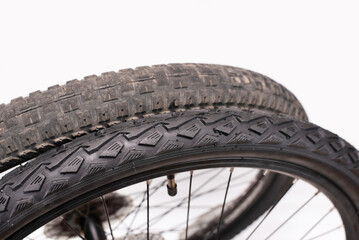 A new cycling season is starting, it's time to change bicycle tires, a comparison of a wide old tire with a new narrower one with large spikes