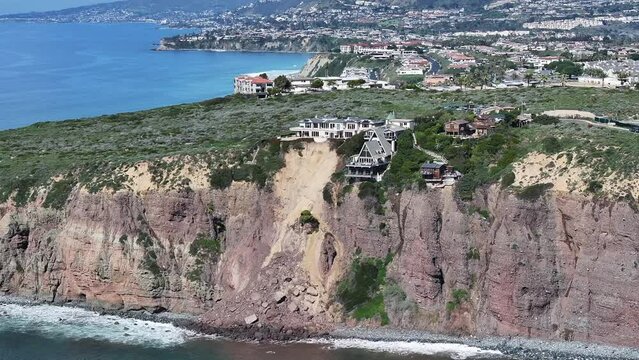 Aerial view drone shot of three houses on Scenic Drive in Dana Point Orange County after a cliffside landslide mudslide gave way amid heavy rain storm.