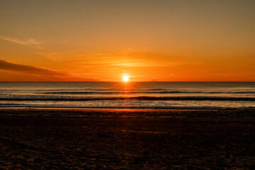 The Sun rising from the Atlantic Ocean across calm waves