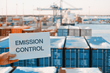 Obraz premium Banner Poster Paper With The Phrase Emission Control With A Logistics Terminal In The Background