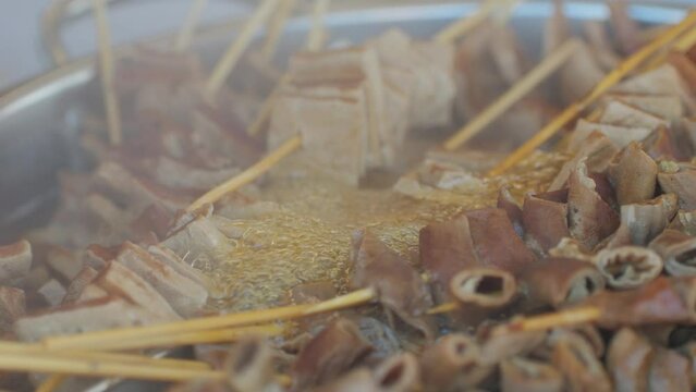 Traditional chinese spicy chicken gizzards close-up. Asian chicken stomach popular food. Local street food market outdoor.