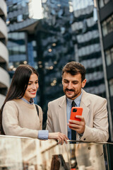 Businessman and businesswoman converse in city center