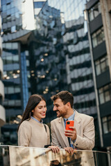 Businessman and businesswoman converse in city center