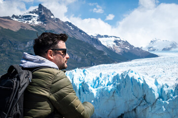 Hombre turista admirando el Glaciar Perito Moreno, desde las pasarelas del Parque Nacional Los Glaciares - obrazy, fototapety, plakaty