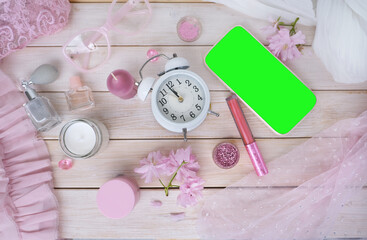 coffee cup, smartphone with blank green screen, cosmetics, perfume in spray bottle, donut, sakura flowers, good morning concept, coffee time in boudoir, female life