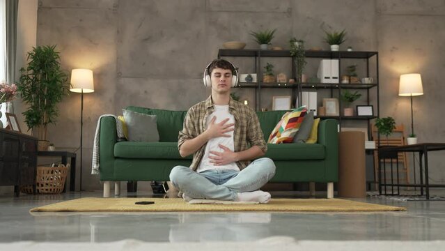 One teen man doing guided meditation yoga self care practice at home