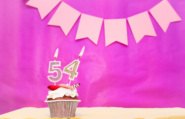 Background date of birth with number  54. Pink background with a cake and burning candles, save...