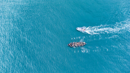 Aerial drone top down photo of sport boat operated by team in emerald calm sea waters with support