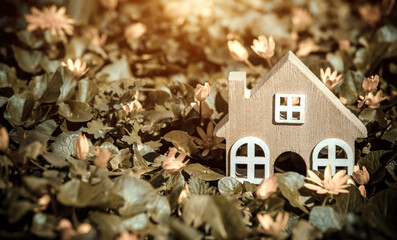 The symbol of the house stands among the yellow flowers
