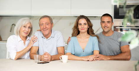 Family of four sitting in kitchen at table close-up