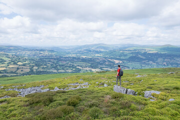 Obraz premium Hiker Backpacker on the mountain of Abergavenny, wales, England, summer outdoor