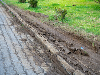 Ruts on the lawn. Destroyed lawn. Tire tracks in the mud. Offset track.