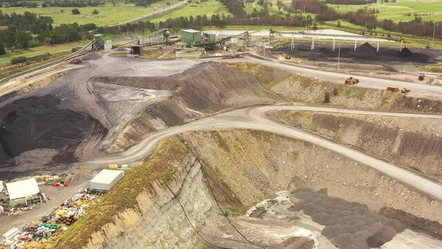 Aerial over deep open pit excavated black coal mine in Hunter valley of Australia 4k.
