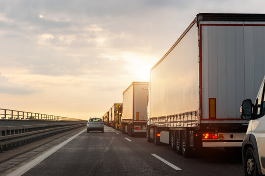Queue of Trucks on Ukraine-Poland Border traffic jam at Sunset During Protest Roadblock. Business agricultural Logistics blockade action. Cargo lorry semi-trailers stuck
