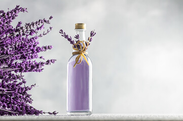 Glass bottle of Lavender essential oil with dried lavender flowers and seeds, close up aromatherapy spa massage concept. Lavendula oleum