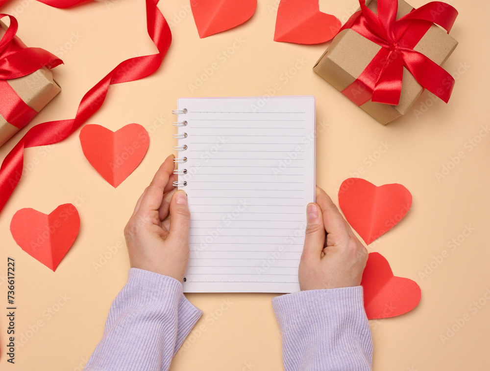 Poster open notebook with empty white sheets and gift boxes around on a yellow background, top view.