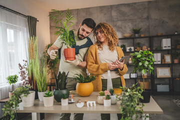 Couple man and woman wife and husband take care of plants at home