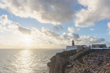 Sunset at lighthouse of Cabo de Sao Vicente with sunlight shining through clouds, Sagres, Algarve,...