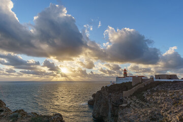 Sunset at lighthouse of Cabo de Sao Vicente with sunlight shining through clouds, Sagres, Algarve,...