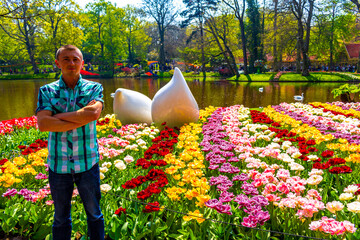 Man tourist with tulip flowers in park in Lisse Netherlands.