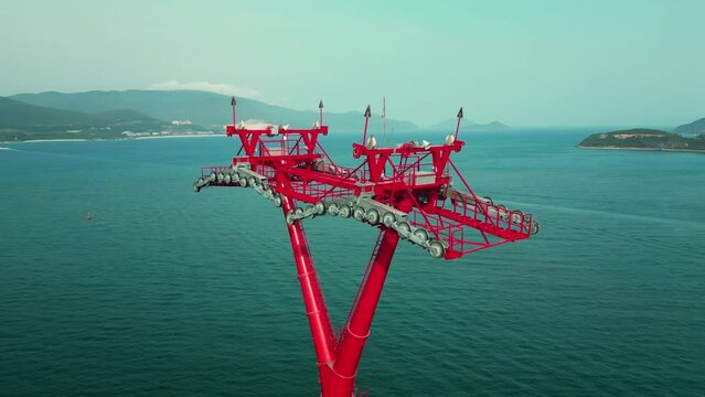 Top view above around huge structure of the power tower of the cable car in the sea with a length of several kilometers, one longest cable cars in the world. Support movement funicular cable car. 4K.