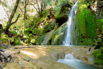 Cascada de agua sobre rocas recubiertas de musgo efcto seda.