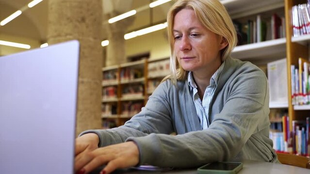 Remote work middle-aged woman using computer in a co-working Freelancer, committed to her craft, dedication and flexibility, professional independence. Employee online video conference with teammates