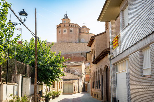 a narrow street with a view to the church of the Assumption (El Piquete) in Quinto town, province of Zaragoza, Aragon, Spain