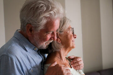 One senior man hug senior lady from behind to love and protect. Elderly lifestyle life together people. Retired couple at home thinking. Romantic sene with male and female having care each other