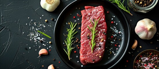 Homemade relaxation: Cook Black Angus striploin steak with garlic, rosemary, black pepper, Himalayan pink salt on black plate.