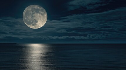 A full moon is shining over the ocean.