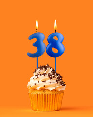 Blue candle number 38 - Birthday cupcake on orange background