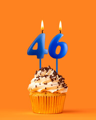 Blue candle number 46 - Birthday cupcake on orange background