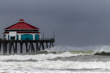 End of  Huntington Beach Pier, California, USA on Dark Stormy Day with Large Waves and Lots of Spray with Shadow Waves--No People, horizontal