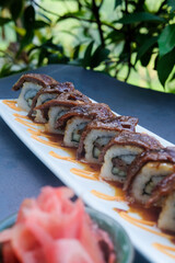 Beef teriyaki roll served on a black wooden plate, avocado, cucumber, lump crab meat, sushi menu, social media post, food photography, fine dining, Japanese food, purple background