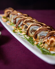 Beef teriyaki roll served on a black wooden plate, avocado, cucumber, lump crab meat, sushi menu, social media post, food photography, fine dining, Japanese food, purple background