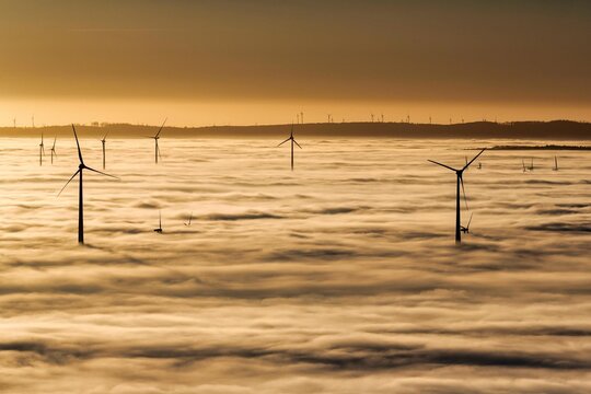 Wind turbines rising from cloud cover, silhouettes at sunset, Koeterberg, Luegde, Weserbergland, North Rhine-Westphalia, Germany, Europe