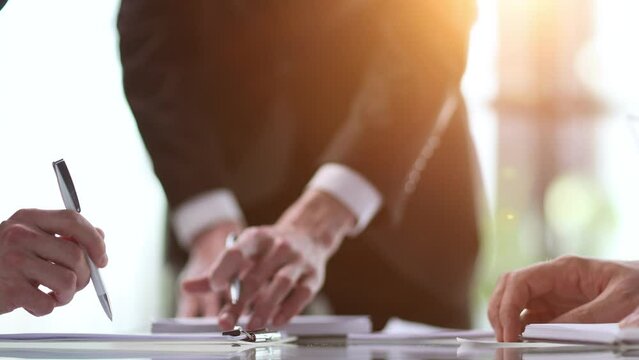 businessmen shaking hands, after concluding a modern cooperation agreement in the office and financial paper graphics on the table
