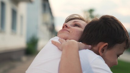 Mother and little son meeting to each other hugging with love and tenderness suburb outdoor...