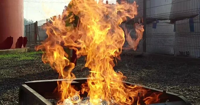 Bombero apagando fuego del incendio en una empresa con extintor rojo