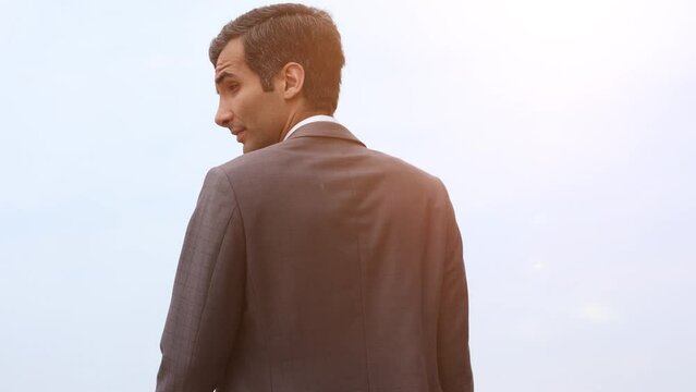 Modern businessman smiles and stretches his hand to the camera wishing to greet