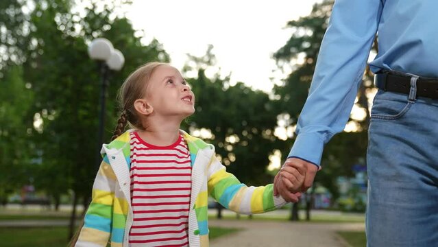 concept happy family park, father affection child kid, parental lifestyle, child touching father hand sunset, orphan walk park, dad holding kid girl hand, man child walking sunset park, family