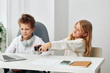 Happy children studying at home using laptops and headphones, immersed in online education A boy...