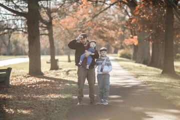 Obraz premium Fathers Day. Brothers and their dad enjoying time together in nature.Candid real family moment.