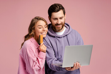 Beautiful couple young couple wearing stylish clothes using laptop smiling woman holding credit card