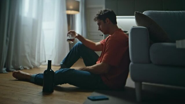 Drunk guy thinking problems feeling loneliness at home. Man drinking alcohol