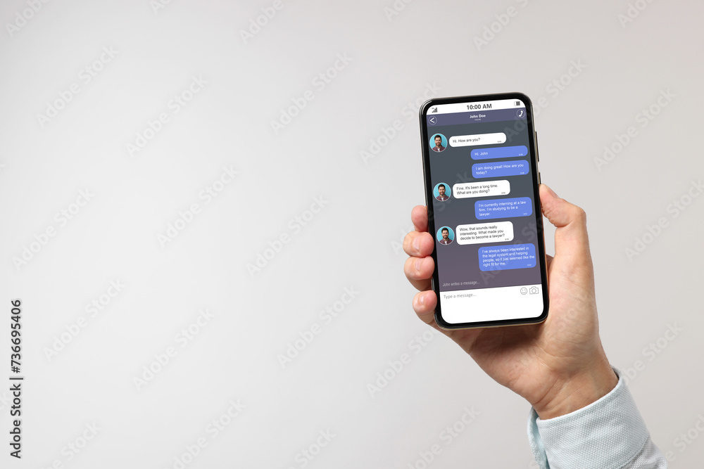 Poster man texting with friend using messaging application on smartphone against light grey background, clo