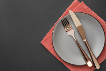 Clean plate, cutlery and napkin on grey table, top view. Space for text
